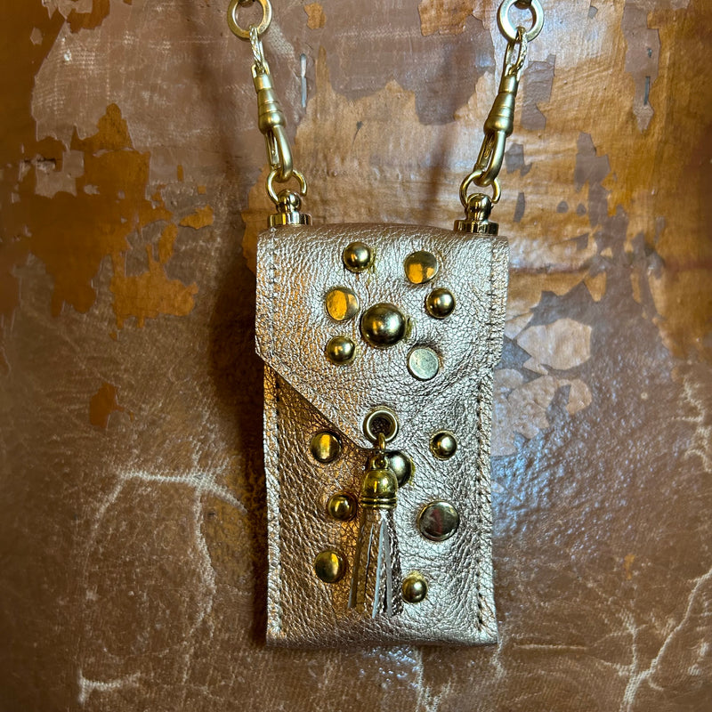 Close up of stud embellishments on gold leather lipstick pouch on chain.