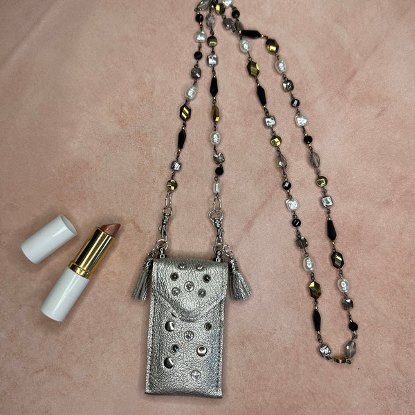 Flat lay of silver leather pouch necklace on luxury mixed bead chain.