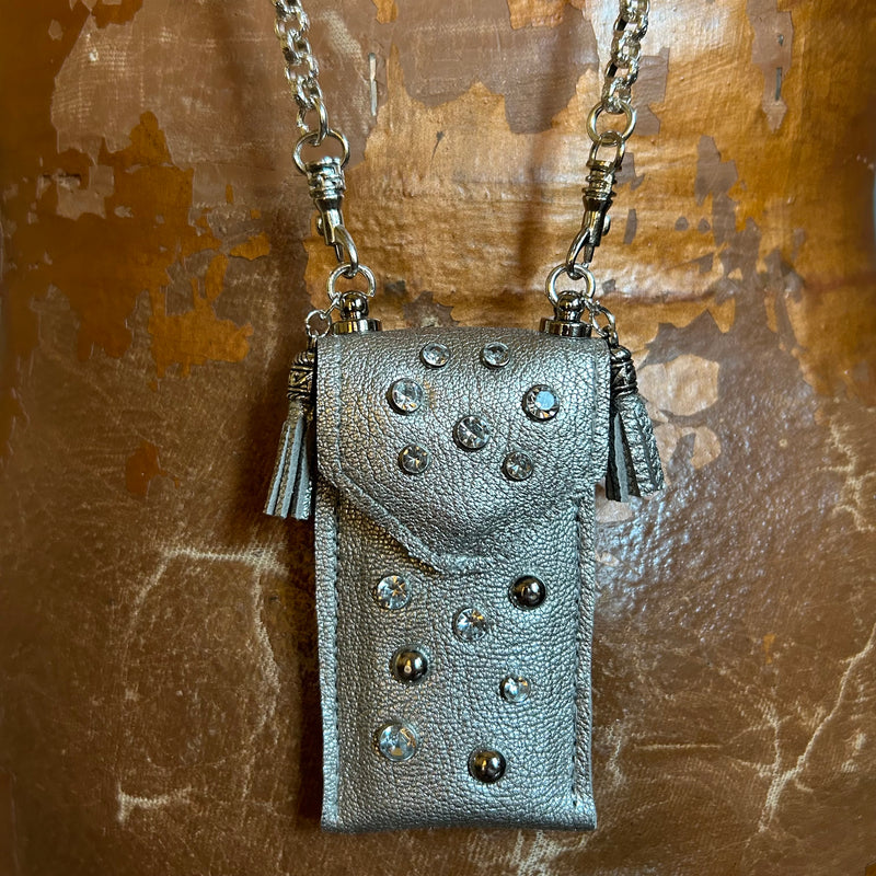Close up of silver chain and crystal & stud accents on silver leather pouch necklace. 