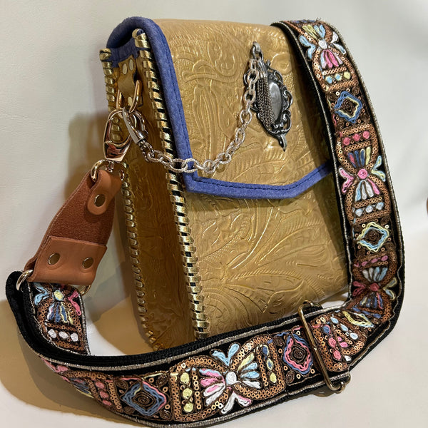 Side view of metallic gold leather crossbody bag with boho strap. 