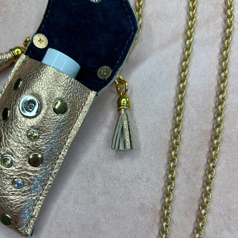 Details of gold leather pouch necklace, suede interior, crystals and gold nailheads. 