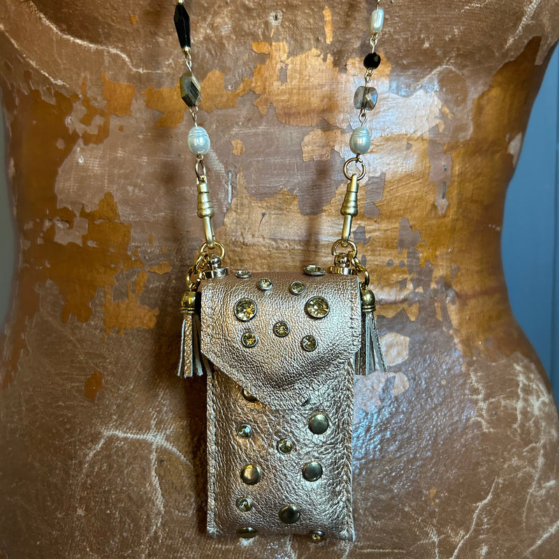 Close up of gold leather pouch necklace on mixed bead chain. 