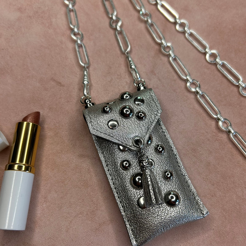 Close up of mixed silver studs on silver leather pouch necklace.