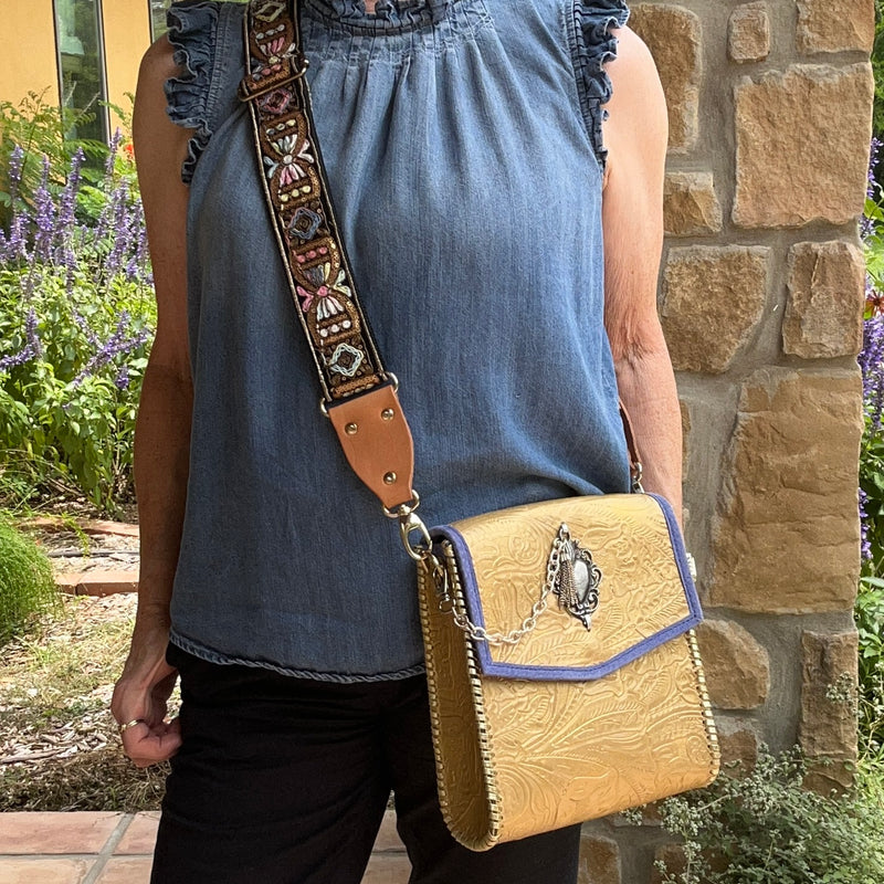 Metallic gold crossbody bag with boho strap styled with casual denim outfit