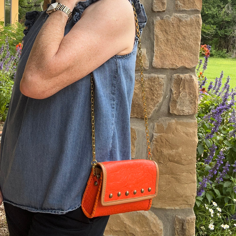 Orange croc print leather mini bag with tan trim styled with casual denim outfit