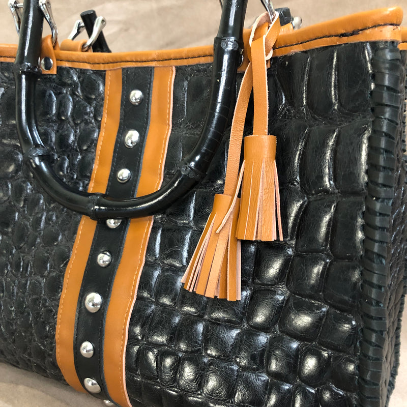Close up view of black croc print leather tote with chestnut brown trim & bamboo handles.