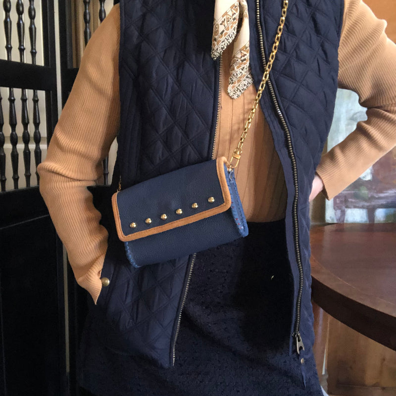 Styled navy & tan leather mini bag with navy blue ensemble. 