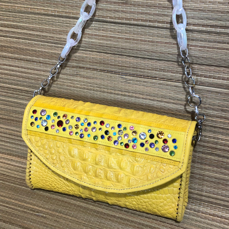 White fluorescent acrylic chain handle on yellow croc print leather clutch with multicolored crystals