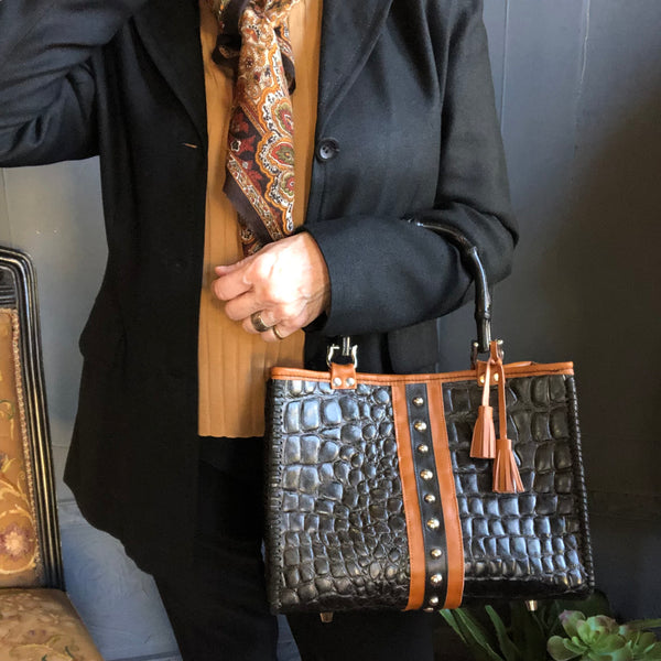 Styled view with black blazer outfit carrying the black croc print leather tote with chestnut brown leather trim & bamboo handles.