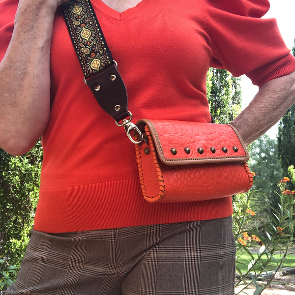 Styled  orange croc leather mini bag with tan trim shown with orange and brown ensemble.
