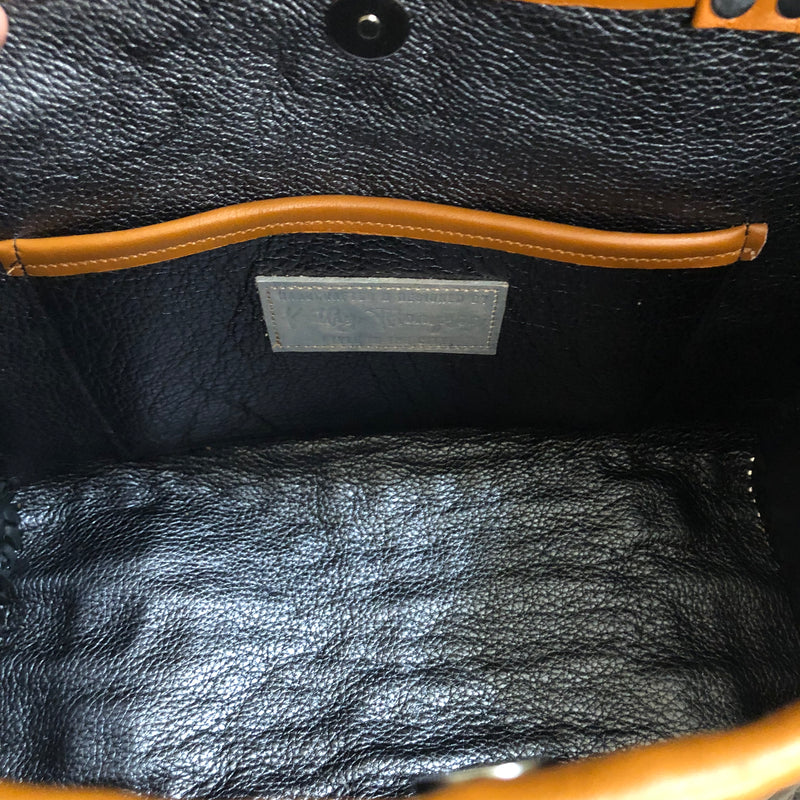 Interior leather lining with open pocket of black croc print leather tote with chestnut brown trim & bamboo handles. 