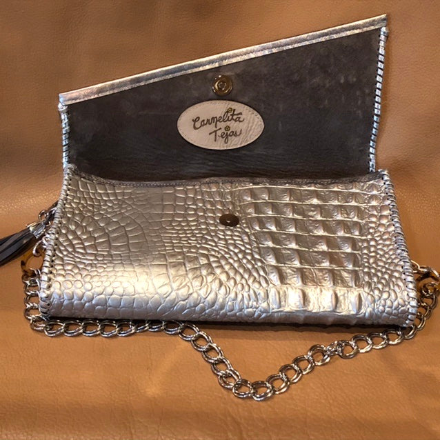 Interior view of angled flap and suede lining on metallic silver leather clutch with springbok & nailhead accents