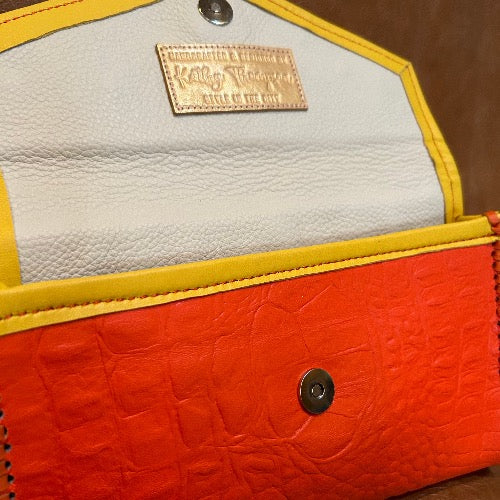 Interior view of cream leather lining of orange croc print leather clutch