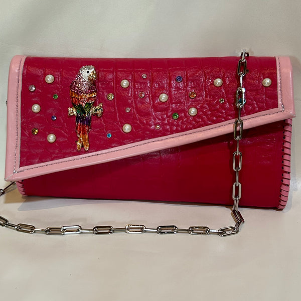 Bright colored crystal magenta pink leather clutch with chain handle.