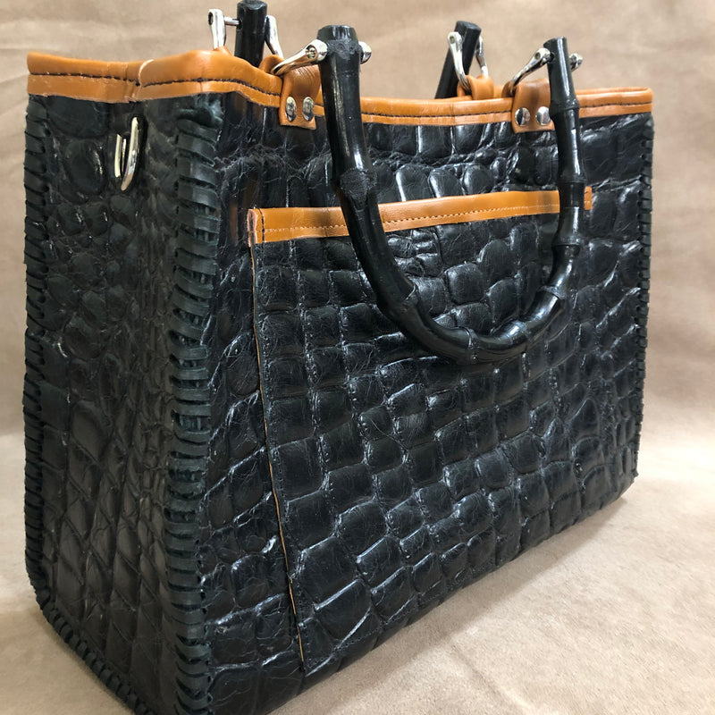 Back view of large open phone pocket on black croc print leather tote with bamboo handles.