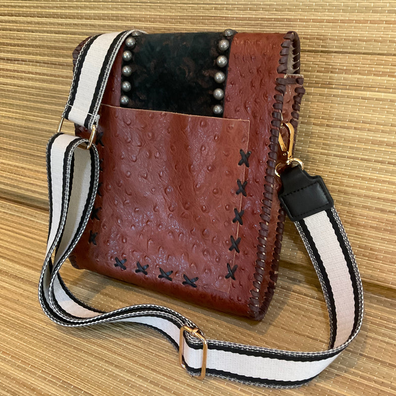 Back view of brown ostrich print leather crossbody with large open pocket for phone. 
