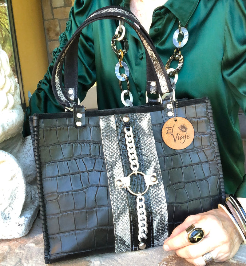 Styled view of black croc print leather tote bag with green outfit