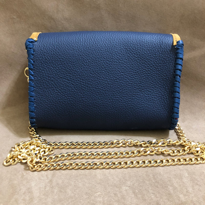 Back view of navy & tan leather mini bag with long gold chain.