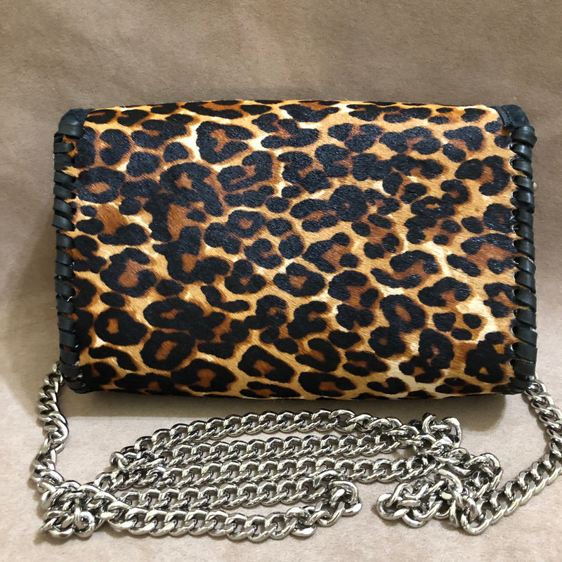 Back view of leopard print leather mini bag on long silver chain. 