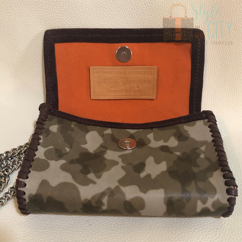 Interior view of orange suede lining on olive camo leather mini bag