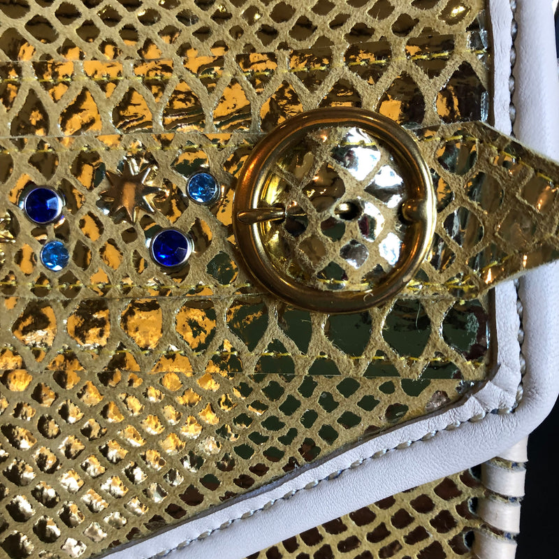 Close up of blue crystal embellished gold snake print leather clutch