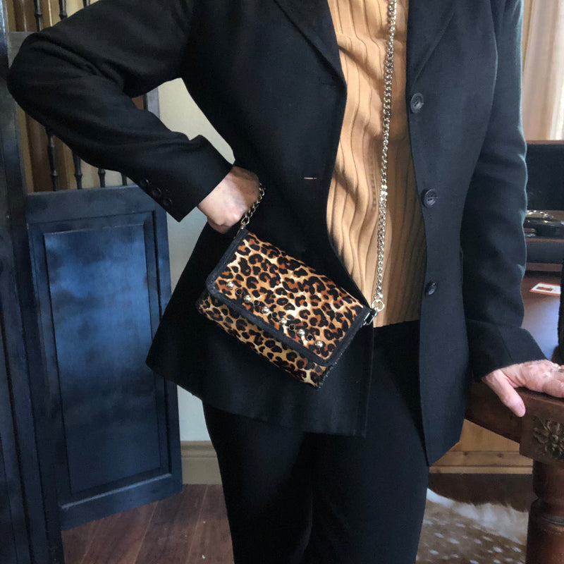 Styled leopard print leather mini bag worn with black blazer. 