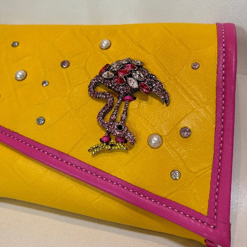 Close up of bejeweled front of yellow croc print leather clutch bag