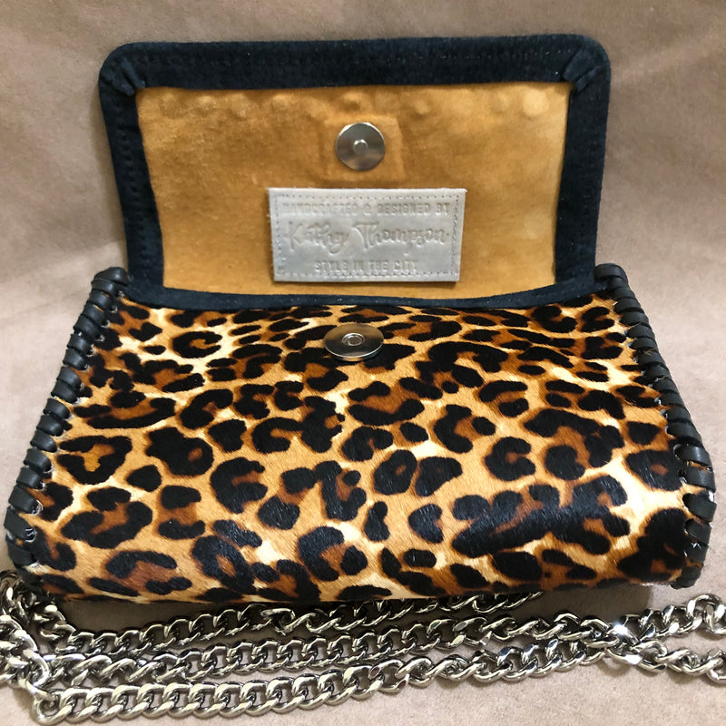Tan suede interior of leopard print leather mini bag.