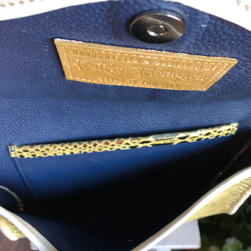 Interior view of navy blue leather lining of gold snake print leather clutch