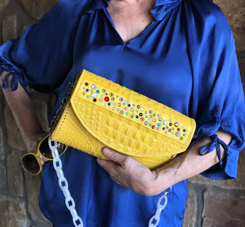 Yellow croc print leather clutch with multicolored crystals styled with blue outfit