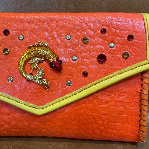 Close up of fish and crystal embellishments on orange croc print leather clutch